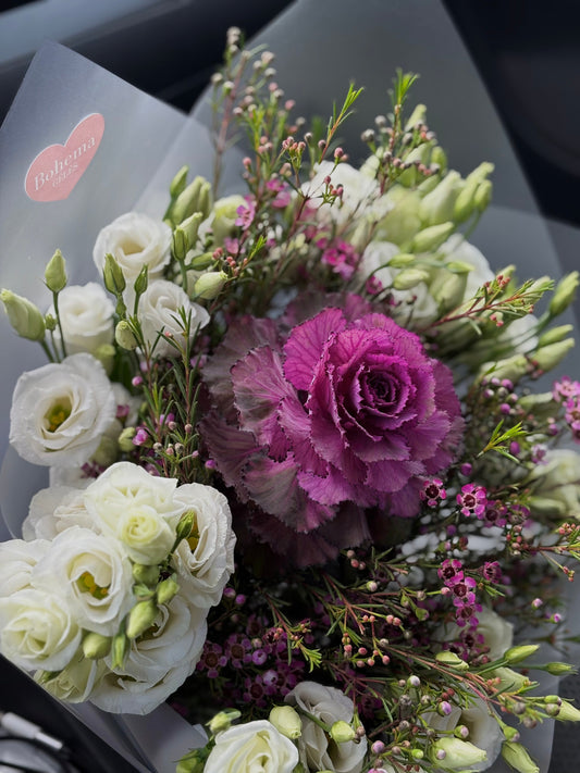 Šviesių atspalvių gėlių puokštė su ryškesniu akcentu centre, subalansuota, vidutinio tankumo kompozicija